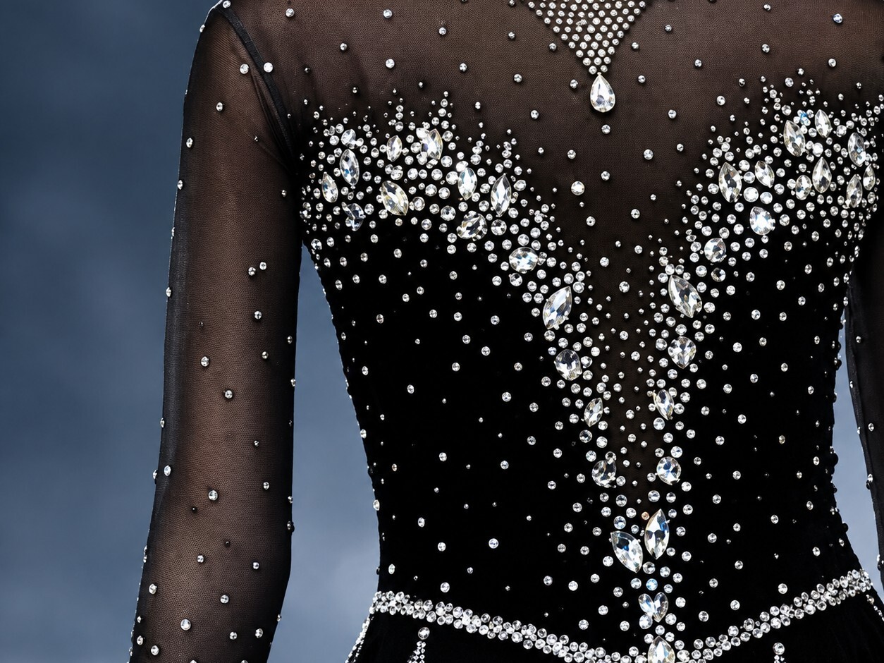 Crystal cascade detail on the back of a black mesh skating costume