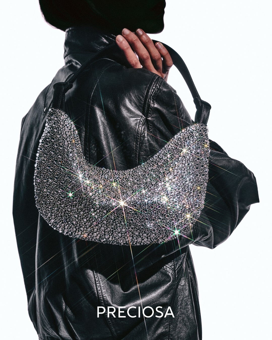 Crystal-covered shoulder bag made with Preciosa MAXIMA over a black leather jacket