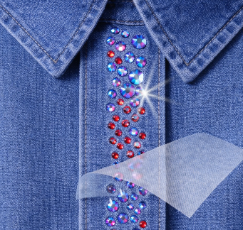Hotfix rhinestone transfer being applied to a denim jacket collar